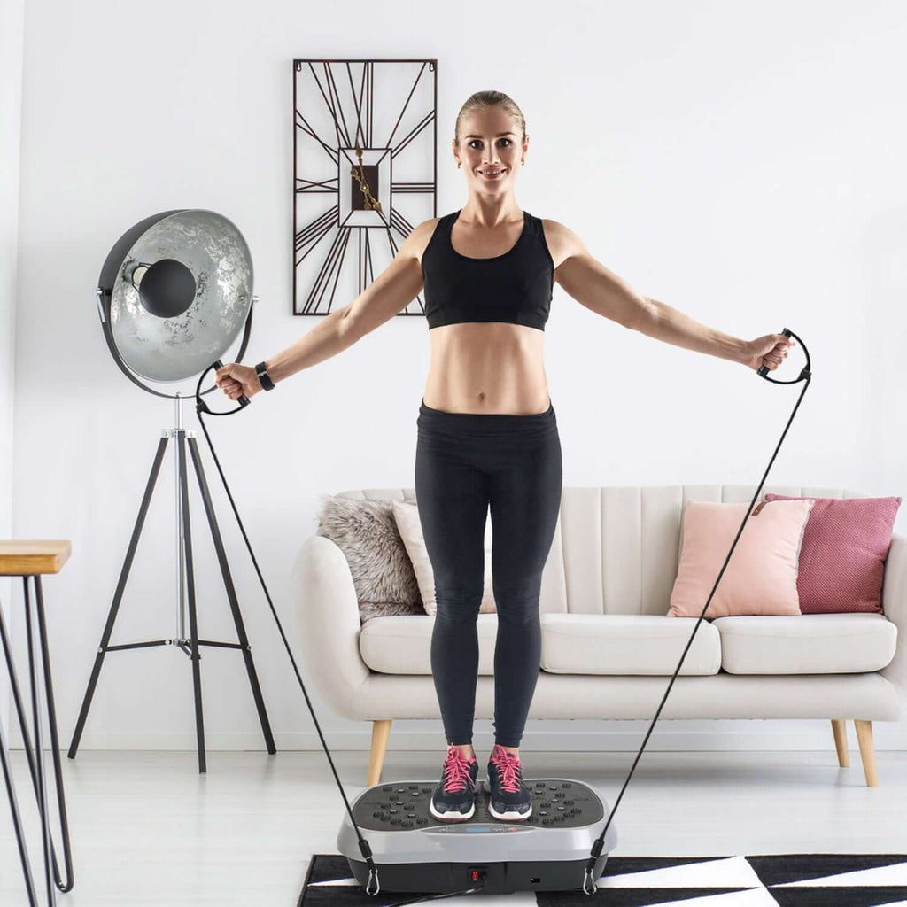 Vibration exercise machine with resistance bands and remote control for full-body workouts at home.