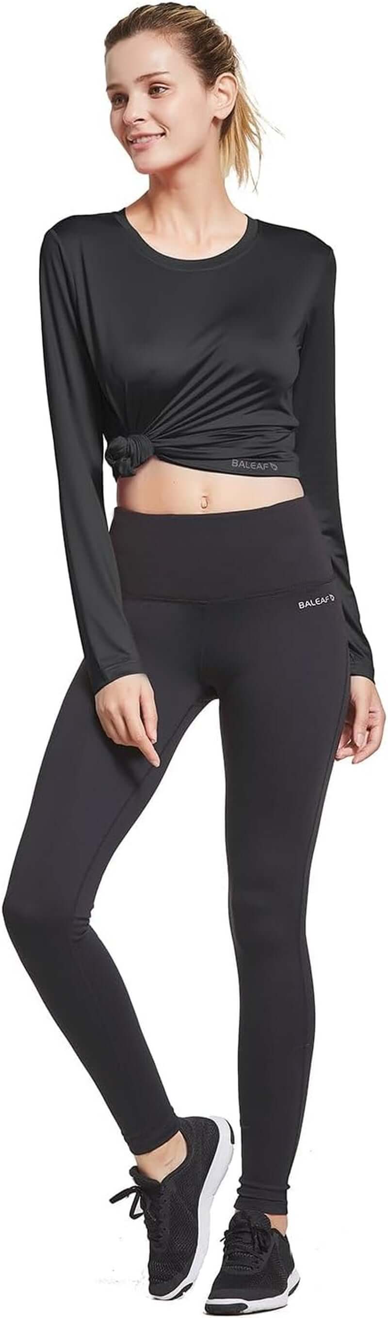 Back view of women's quick dry workout top in black, showcasing long sleeves and stylish design.